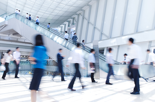 Busy office atrium with people in business attire walking